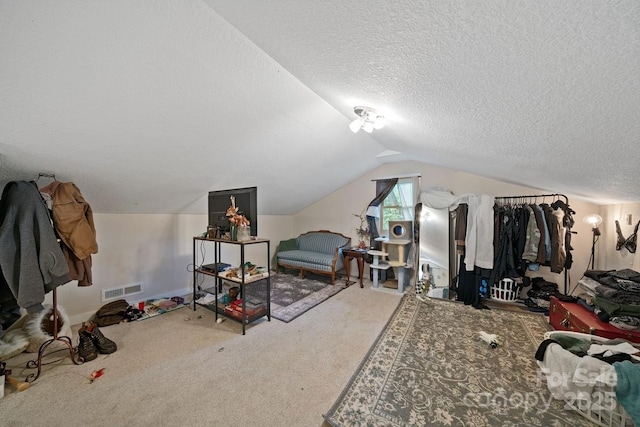 bedroom with visible vents, carpet floors, a textured ceiling, and vaulted ceiling