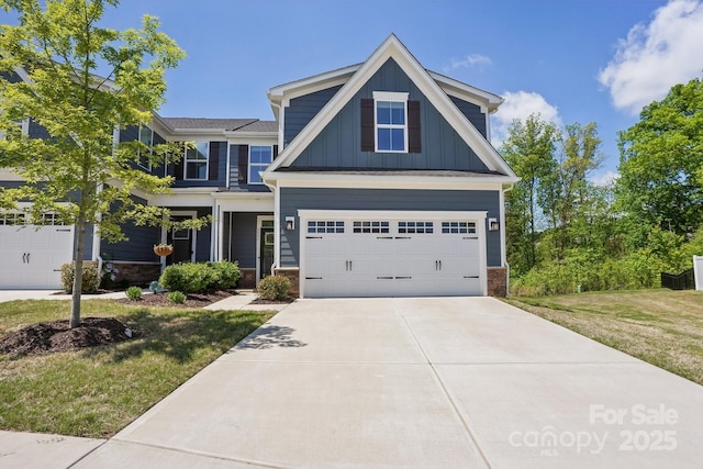 craftsman-style house featuring board and batten siding, stone siding, a front yard, and concrete driveway