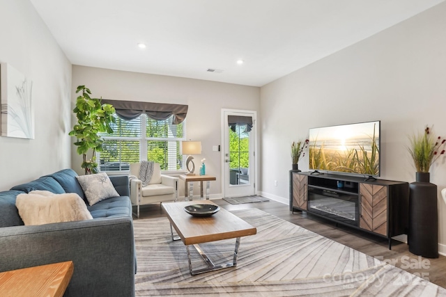 living room featuring baseboards, recessed lighting, and wood finished floors