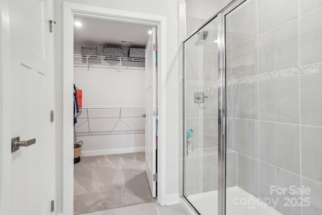 full bathroom with a walk in closet and a stall shower