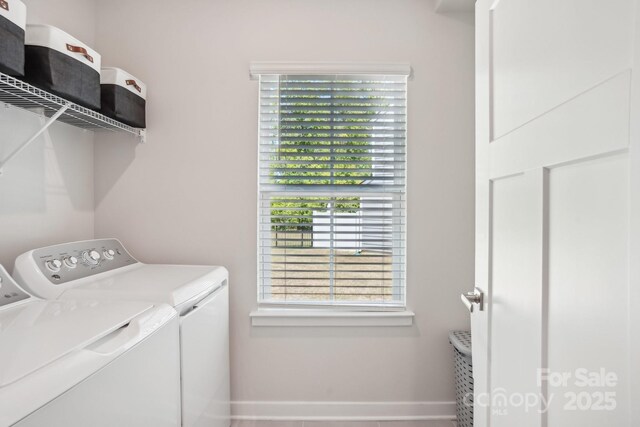 washroom featuring baseboards, laundry area, and washing machine and clothes dryer