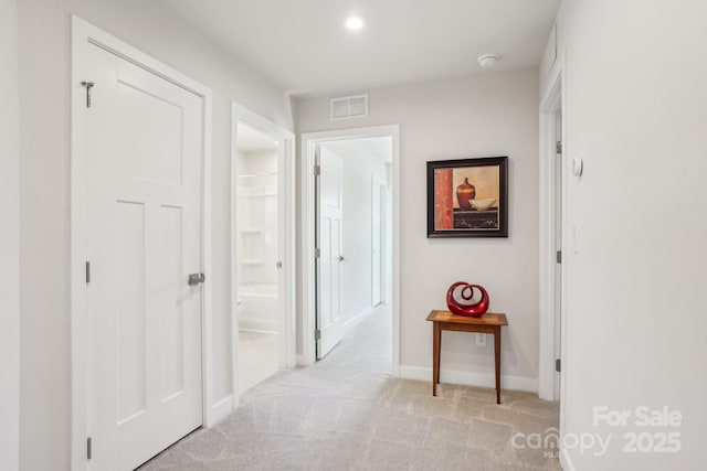 hallway with baseboards, light carpet, recessed lighting, and visible vents