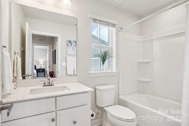 bathroom featuring visible vents, vanity, toilet, baseboards, and shower / bath combination