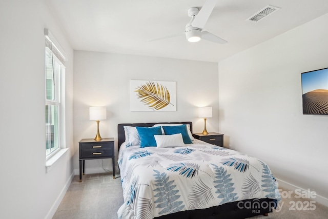 carpeted bedroom with baseboards, multiple windows, a ceiling fan, and visible vents