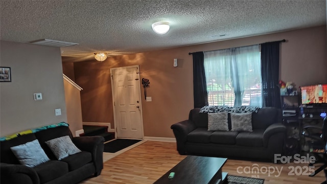 8524 Stoneman Pl, Charlotte, NC 28217 - living room with visible vents, stairs, a textured ceiling, and wood finished floors