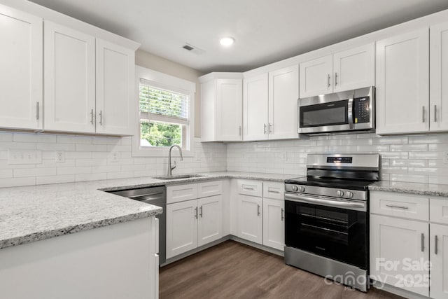 236 Elizabeth Ave, Forest City, NC 28043 - kitchen with visible vents, appliances with stainless steel finishes, dark wood finished floors, a sink, and white cabinets