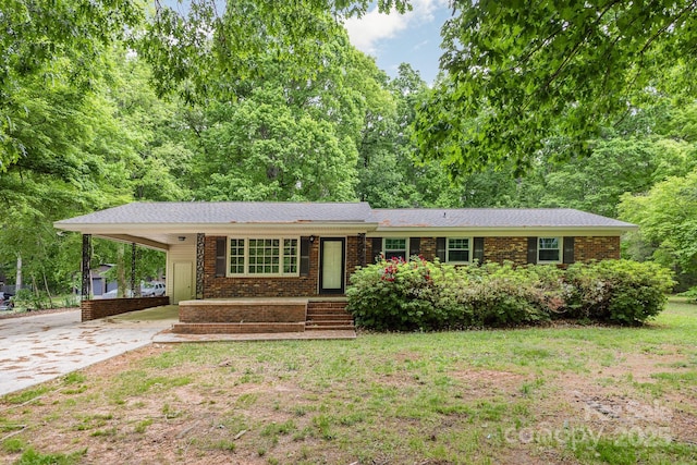 ranch-style house with an attached carport, concrete driveway, and brick siding