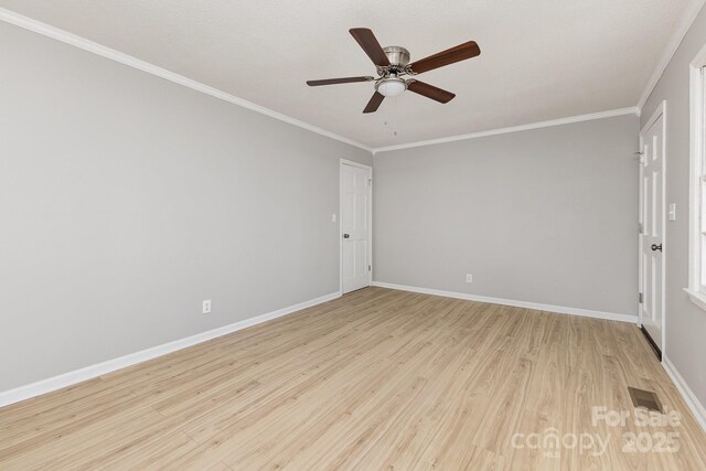 unfurnished room with ceiling fan, visible vents, crown molding, light wood-type flooring, and baseboards