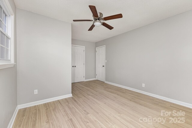 unfurnished room with baseboards, ceiling fan, and light wood finished floors