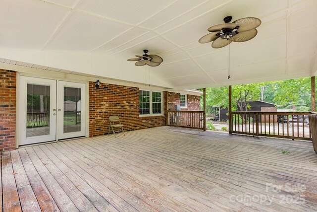 wooden deck featuring an outdoor structure, a ceiling fan, french doors, and a shed