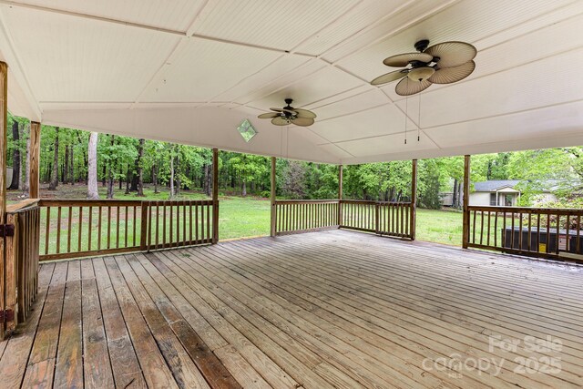 deck with a ceiling fan, a yard, an outbuilding, and a storage shed