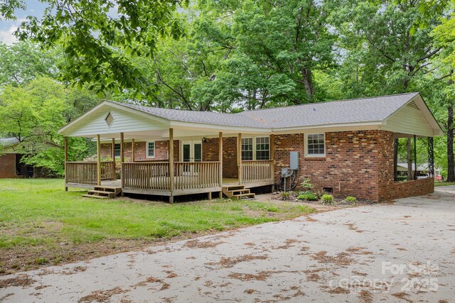 ranch-style home featuring brick siding, driveway, a shingled roof, and a front yard