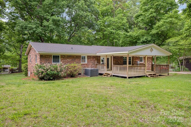 back of property featuring cooling unit, a yard, crawl space, and brick siding