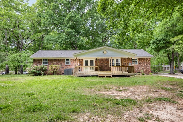 rear view of house featuring central air condition unit, brick siding, a yard, and french doors
