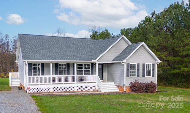 view of front facade featuring a front lawn, a shingled roof, and covered porch