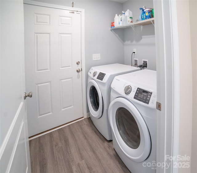 laundry area with wood finished floors, separate washer and dryer, and laundry area