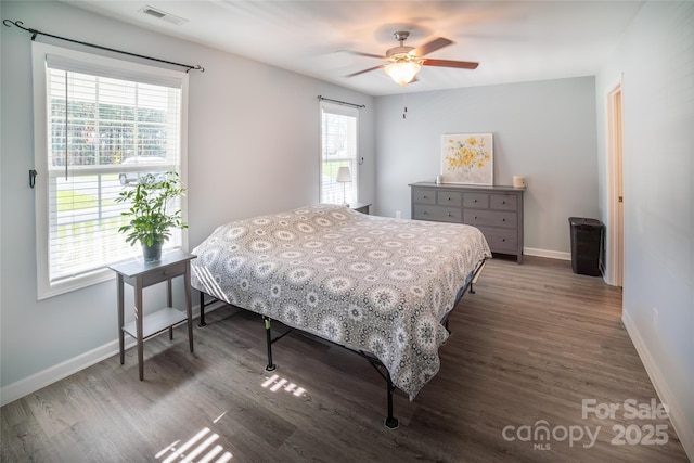 bedroom featuring wood finished floors, visible vents, ceiling fan, and baseboards