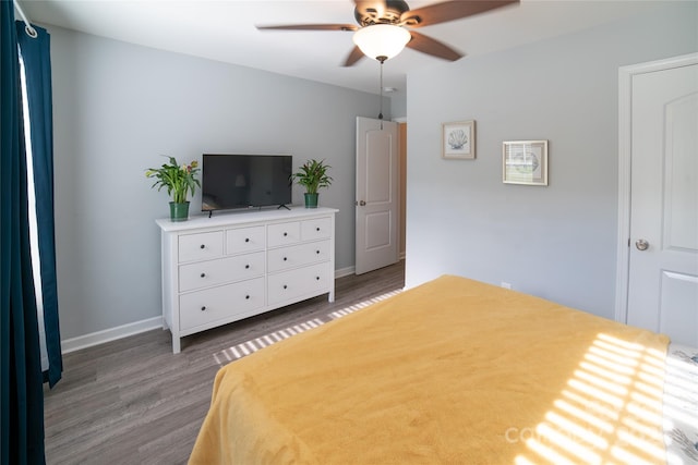 bedroom with baseboards, wood finished floors, and a ceiling fan