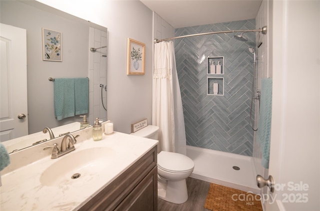 full bathroom with wood finished floors, vanity, toilet, and a stall shower