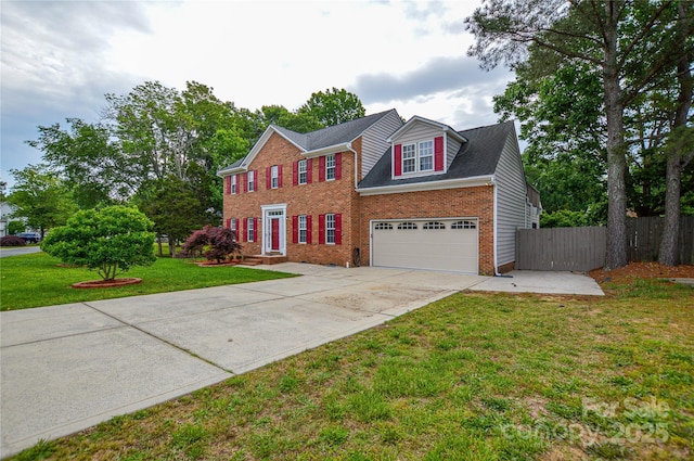 colonial house with driveway, an attached garage, and brick siding