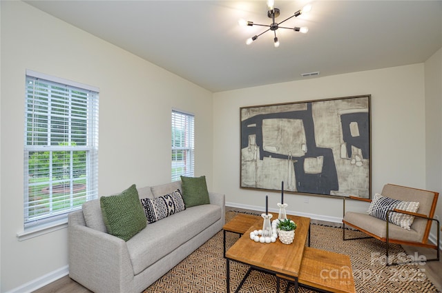 living room with a chandelier, healthy amount of natural light, baseboards, and wood finished floors