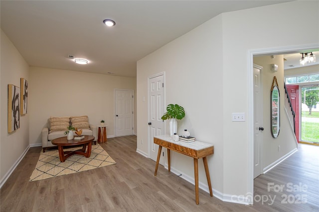 corridor with light wood finished floors and baseboards
