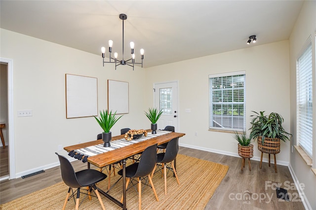 dining room with wood finished floors, a chandelier, and plenty of natural light