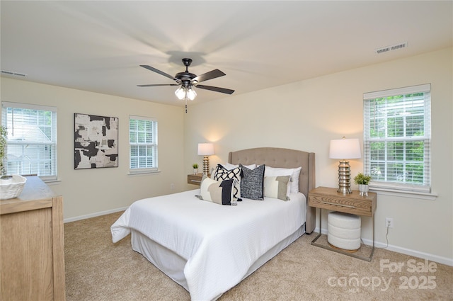 carpeted bedroom featuring multiple windows, baseboards, and ceiling fan