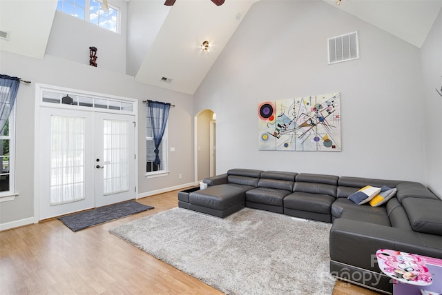 14807 Middlesborough Dr, Matthews, NC 28104 - living room with high vaulted ceiling, arched walkways, wood finished floors, ceiling fan, and french doors