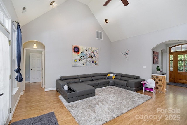 14807 Middlesborough Dr, Matthews, NC 28104 - living area with arched walkways, high vaulted ceiling, a ceiling fan, light wood finished floors, and baseboards