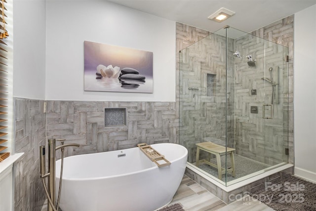 14807 Middlesborough Dr, Matthews, NC 28104 - bathroom featuring tile walls, a stall shower, and a freestanding tub