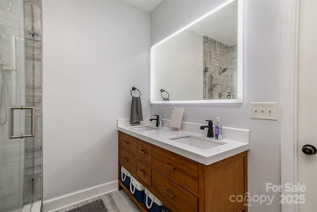 14807 Middlesborough Dr, Matthews, NC 28104 - bathroom featuring a shower stall, double vanity, baseboards, and wood finished floors