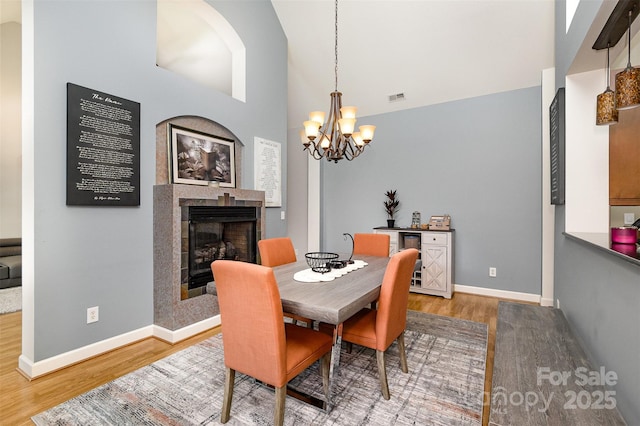 14807 Middlesborough Dr, Matthews, NC 28104 - dining room with wood finished floors, a fireplace, a chandelier, baseboards, and lofted ceiling