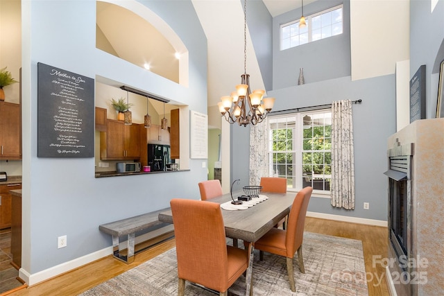 14807 Middlesborough Dr, Matthews, NC 28104 - dining area featuring a chandelier, wood finished floors, healthy amount of natural light, baseboards, and high vaulted ceiling