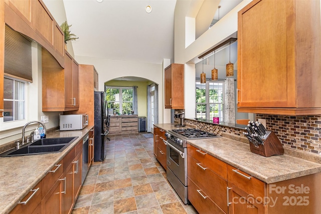 14807 Middlesborough Dr, Matthews, NC 28104 - kitchen with appliances with stainless steel finishes, a sink, backsplash, and arched walkways