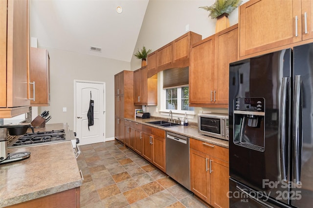 14807 Middlesborough Dr, Matthews, NC 28104 - kitchen with appliances with stainless steel finishes, a sink, high vaulted ceiling, light countertops, and stone finish flooring