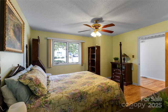 bedroom featuring a textured ceiling, ceiling fan, and wood finished floors