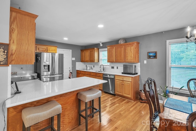 3585 Goodman Lake Rd, Salisbury, NC 28146 - kitchen featuring a sink, stainless steel appliances, a kitchen bar, light wood finished floors, and a peninsula