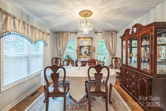 3585 Goodman Lake Rd, Salisbury, NC 28146 - dining space featuring baseboards, wood finished floors, and an inviting chandelier