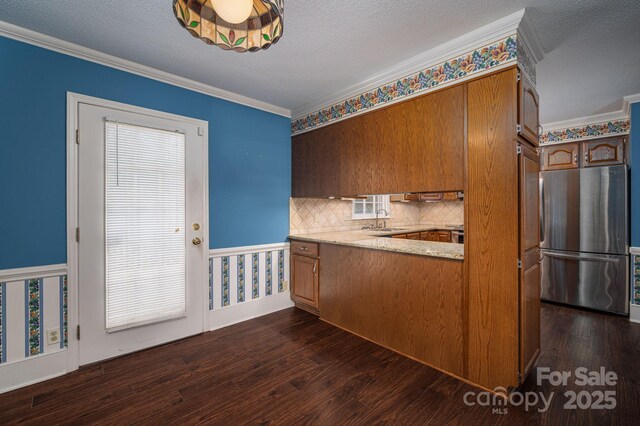 kitchen with freestanding refrigerator, a sink, dark wood-style floors, and ornamental molding