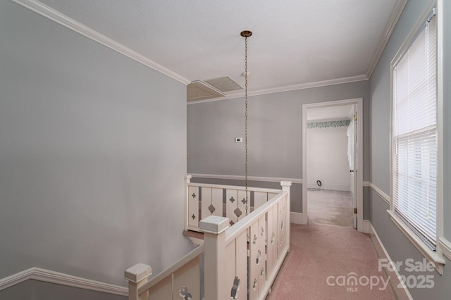 hall featuring ornamental molding, light colored carpet, visible vents, and an upstairs landing