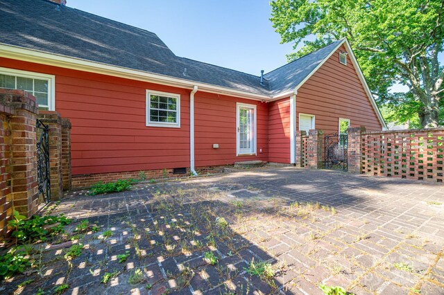 rear view of property featuring fence and a shingled roof