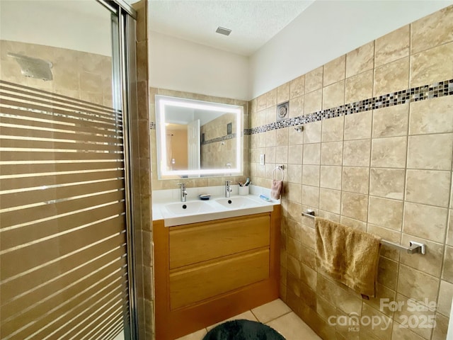 970 Mt Moriah Church Rd, China Grove, NC 28023 - full bathroom with double vanity, decorative backsplash, visible vents, tile walls, and a shower stall