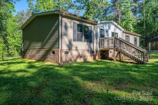view of side of property featuring crawl space, fence, a lawn, and stairway