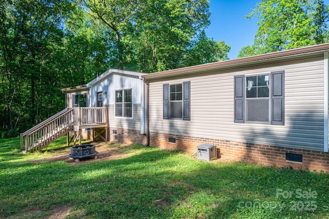 view of property exterior featuring a lawn, an outdoor fire pit, and crawl space