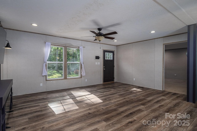 unfurnished living room with wood finished floors, ceiling fan, a textured ceiling, recessed lighting, and crown molding