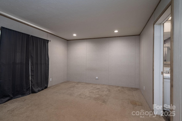 carpeted empty room with a decorative wall and recessed lighting