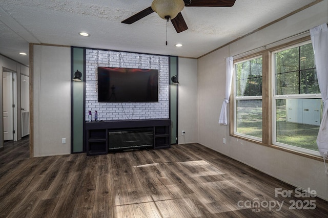 unfurnished living room featuring a textured ceiling, a ceiling fan, wood finished floors, a glass covered fireplace, and recessed lighting