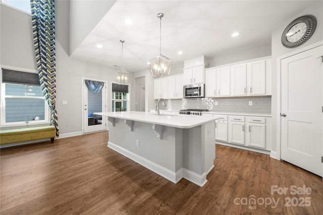 3588 County Down Ave, Kannapolis, NC 28081 - kitchen featuring stainless steel microwave, a chandelier, decorative backsplash, light countertops, and a sink