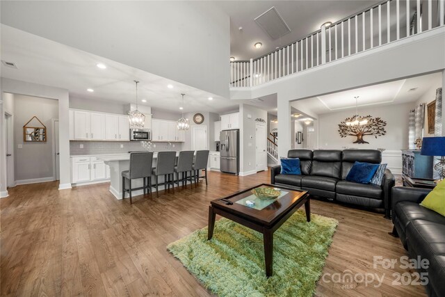3588 County Down Ave, Kannapolis, NC 28081 - living area with a chandelier, light wood-type flooring, stairs, recessed lighting, and a towering ceiling